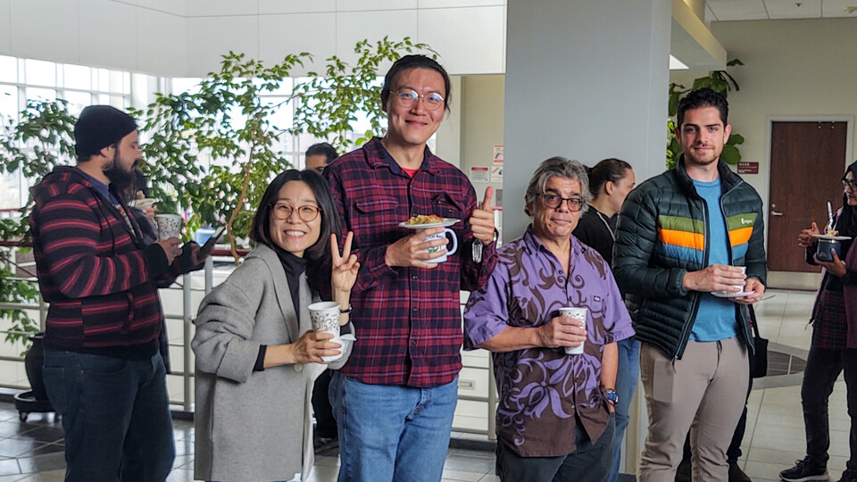 Members of the Department of Biochemistry and Center for Plant Science Innovation hold coffee while smiling for the camera