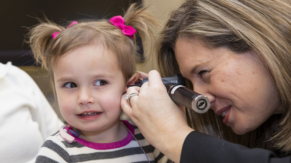 Stacie Ray, associate professor of practice in special education and communication disorders, examines a HearU Nebraska patient. The project received a Women Investing in Nebraska grant in 2014. 