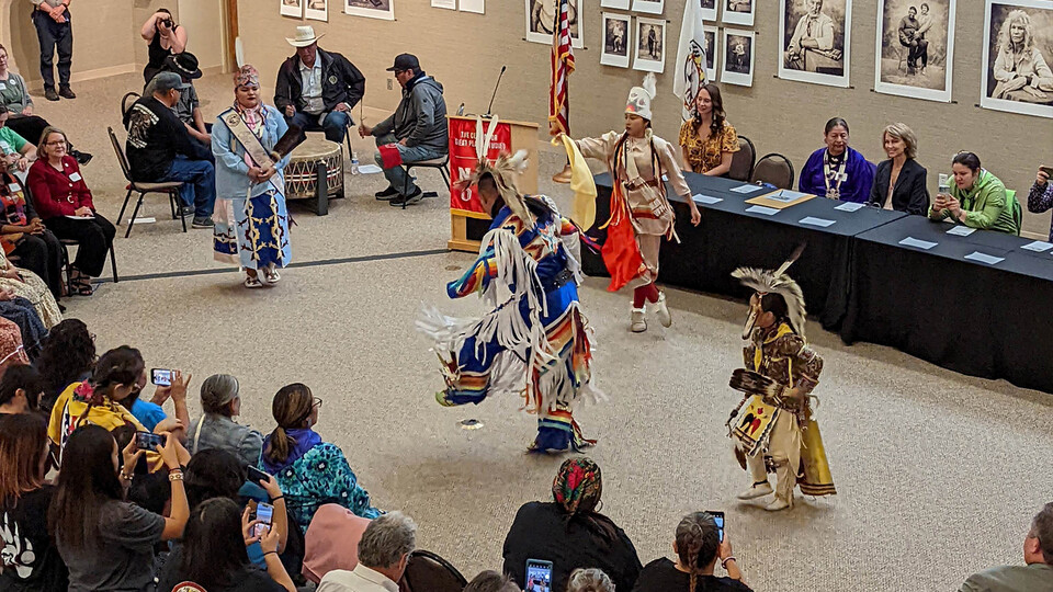 Members of the Otoe-Missouria nation dance as a crowd looks on