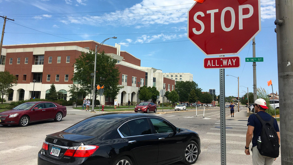 A student waits to cross 16th Street as traffic flows through the intersection along Vine Street. Due to traffic and pedestrian congestion, drivers are being asked to avoid the intersection.