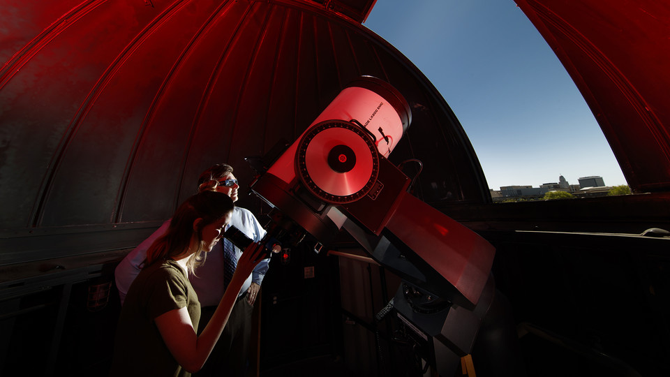 Michael Sibbernsen (right) and Hannah Paxton use the observatory atop the Stadium Parking Garage at the University of Nebraska–Lincoln. The university will use the observatory to record the Aug. 21 total solar eclipse.