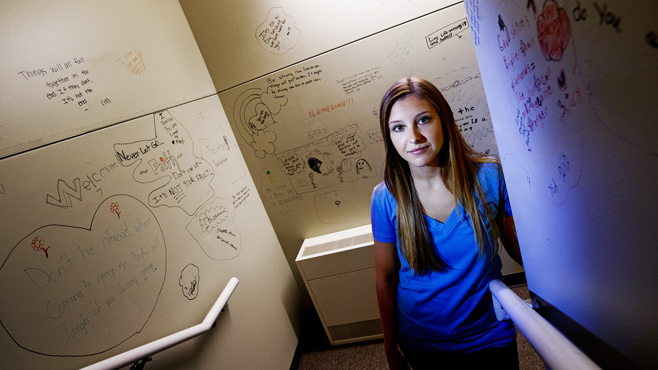 Kate Theimer stands amid abuse victim messages in the stairwell of Lincoln's Child Advocacy Center. Theimer, a Nebraska graduate student, completed a research that found abused teens are more likely to be blamed if the abuse occurred more than once.