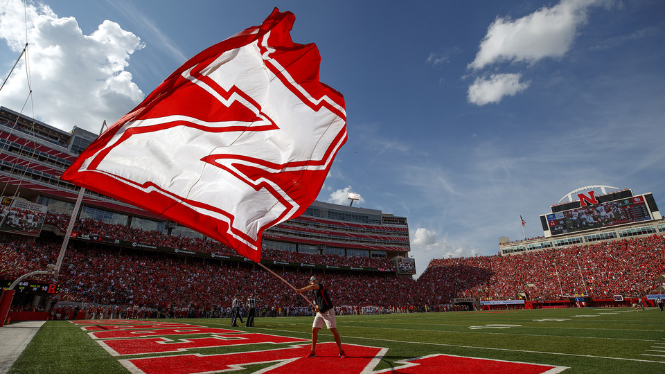 A member of the cheer squad flies the Nebraska flag during the Huskers' 2017 game with Rutgers University in Memorial Stadium. During the Red-White Spring Game on April 21, journalism students will get a real-world experience, working with sports media and communication professionals.