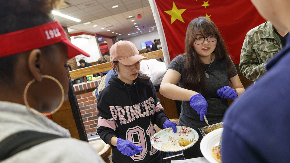 Students who are a part of the Chinese Student and Scholar Association serve dishes during the International Food Bazaar in the Nebraska Union on Nov. 15.