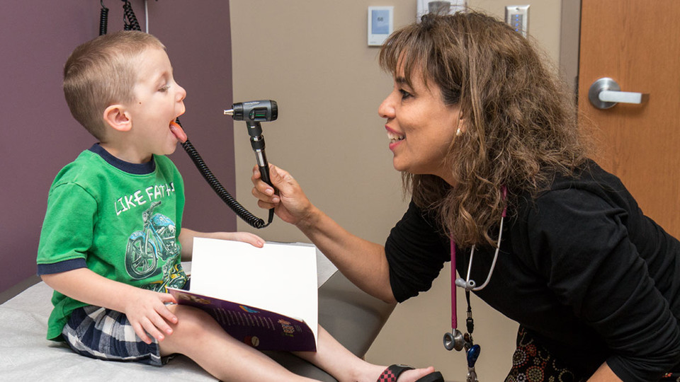 Christina Fernandez, a pediatrician with the Creighton University Medical Center, examines a child. A partnership that included researchers from four Nebraska universities shows promise in assisting parents with early childhood obesity.