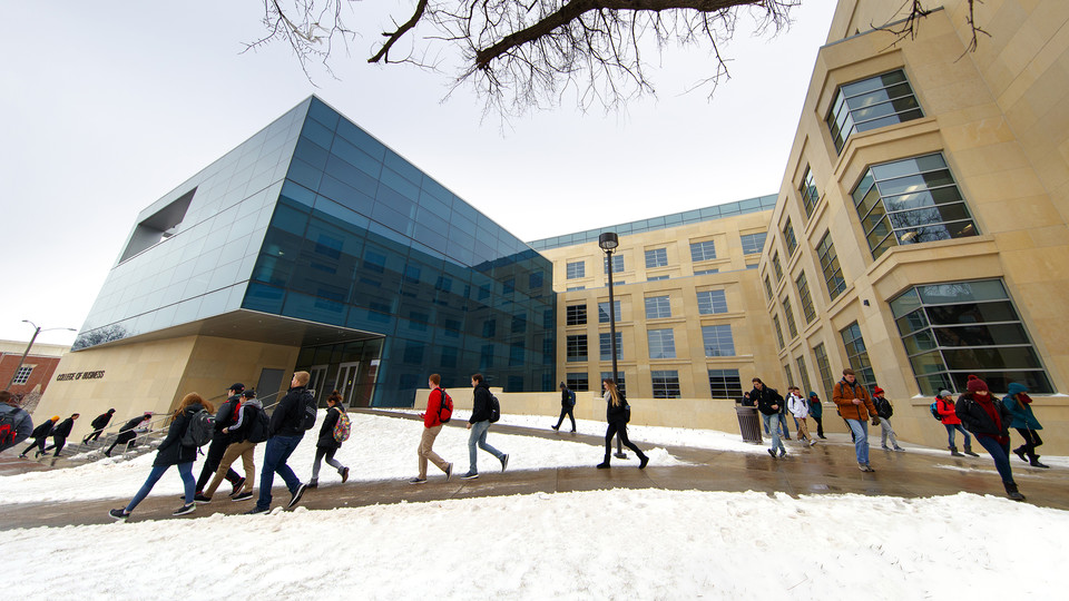Nebraska students walk by Howard Hawks Hall after snow fell earlier this semester. The university issues messages about winter-related closures via the UNL Alert system.