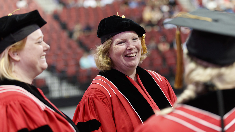 Nebraska's Ann Tschetter shares a laugh with fellow marshals during commencement exercises on Aug. 11 in Pinnacle Bank Arena.