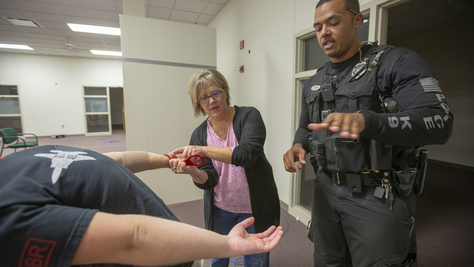 K-9 Officer Russell Johnson Jr. (right) shows Julie Thomsen how to apply handcuffs during the second week of the University Police Department's Citizens' Police Academy. The six-week program is designed to educate members of the campus community about the University Police Department.