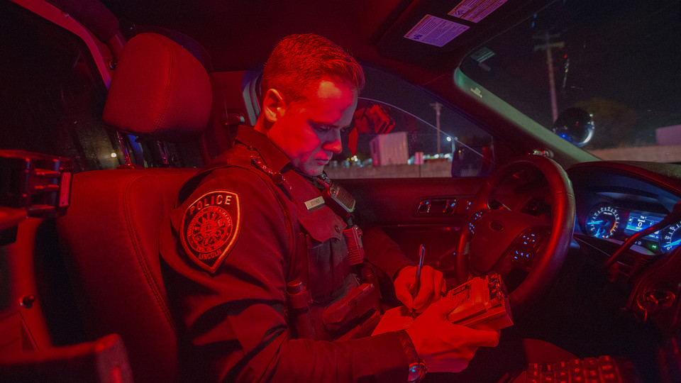 Officer Chadd Stutheit of the University Police Department writes a warning ticket during a traffic stop on Oct. 19.