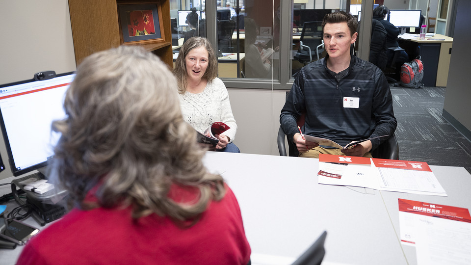Anna Plank, assistant director of Husker Hub, talks with student Ben Houck and his mother, Cheryl, in the temporary home for Husker Hub. The new one-stop shop offers integrated services, including the offices of Scholarships and Financial Aid, University Registrar, Bursar, and Student Accounts. The hub opened in Pound Hall and will move into a permanent space in Canfield Administration Building.