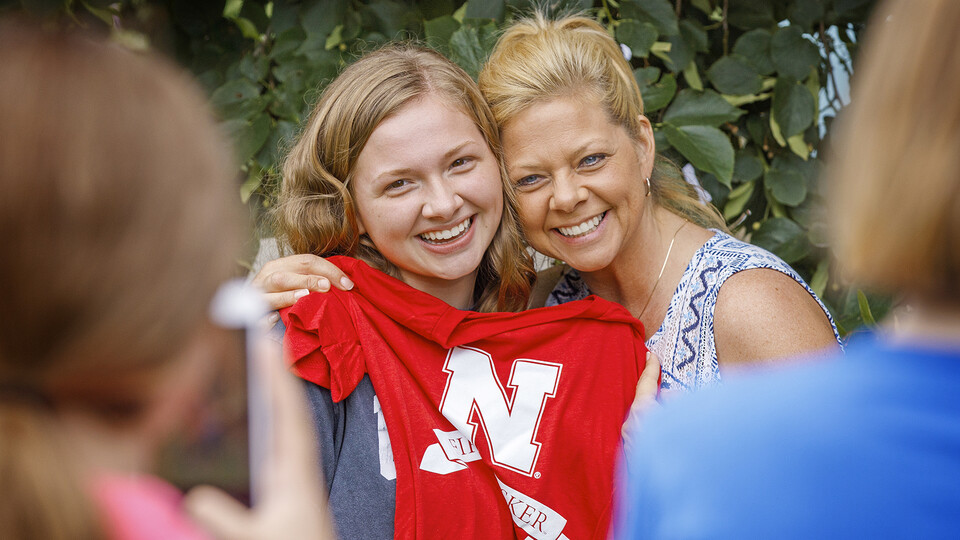 Mother and daughter posing with a red Nebraska t-shirt during a First Husker event in 2019.