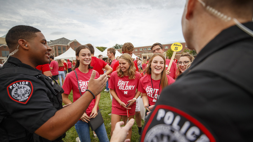 UPD officers Terrell Long (left) and Craig Tepley talk with students during a Big Red Welcome barbecue on Aug. 23. The department will host a Coffee with a Cop Day on City and East campuses on Oct. 2.