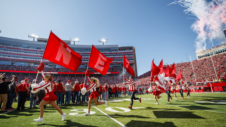 The Husker spirit squad leads the Huskers onto the field in Memorial Stadium on Oct. 5, 2019.