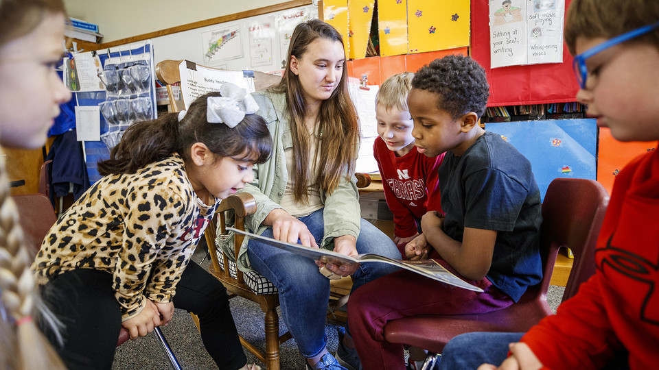Megan Groth, a sophomore speech-language pathology major, reads to first-grade students at Saratoga Elementary school as part of the America Reads/America Counts project.  