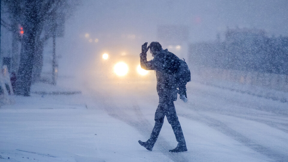A person crosses a street during a Lincoln, Nebraska, blizzard in December 2019.