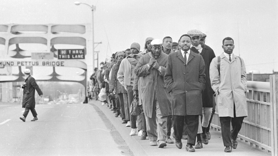 John Lewis (front, right, in trench coat) helps lead protestors across the Edmund Pettus Bridge from Selma, Alabama, to the state capitol building in Montgomery in 1965. 