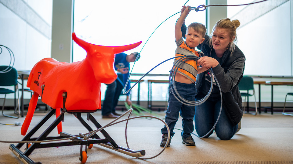 A Husker helps a child swing a lasso and rope a plastic steer during CASNR Community Night. The event was part of the CASNR Week celebration, which started March 9.