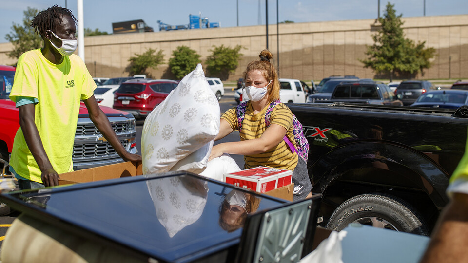 Megan Vincent, of Omaha, adds her last couple items to the bins loaded with her possessions outside of Harper Hall.