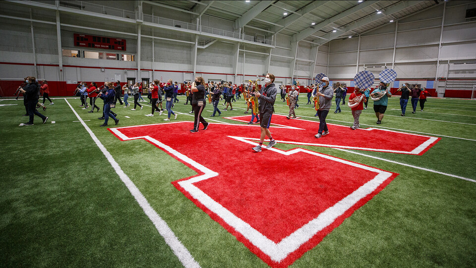 A third of the Cornhusker Marching Band plays during an early-morning practice in Cook Pavilion. As part of its COVID-19 health protocols, the band limits the number of students participating in practice to a maximum of two-thirds of total members. They have also doubled the distance between each musician and are either wearing masks or have the bells of wind instruments covered with cloth.