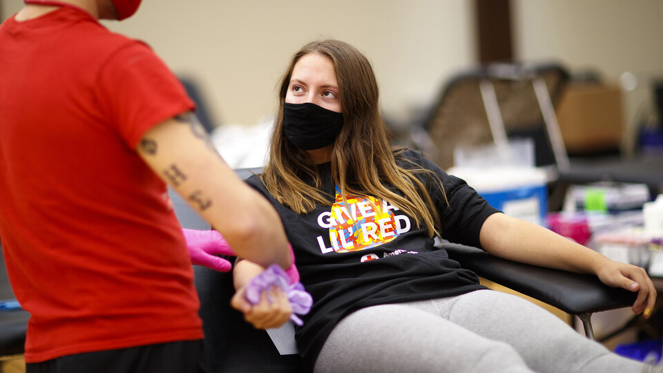 Kacey Heidbrink, a junior from Beatrice, listens to instructions while donating.