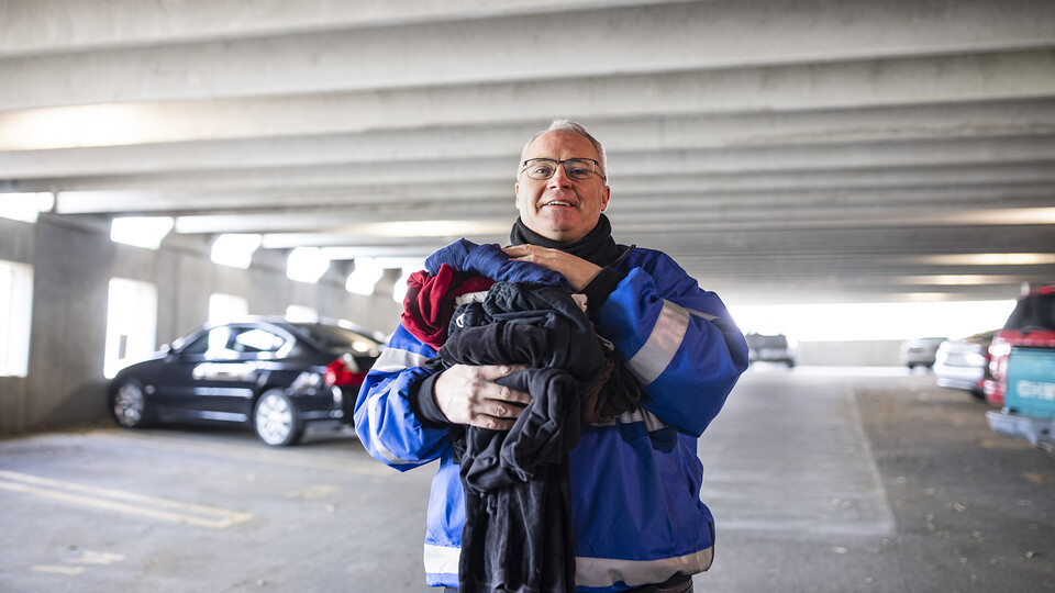 Kirk McManus holds clothing items he's collected for his monthly drives for the People's City Mission. The project is inspired by McManus' childhood, which included helping his parents get out of a debt rut.