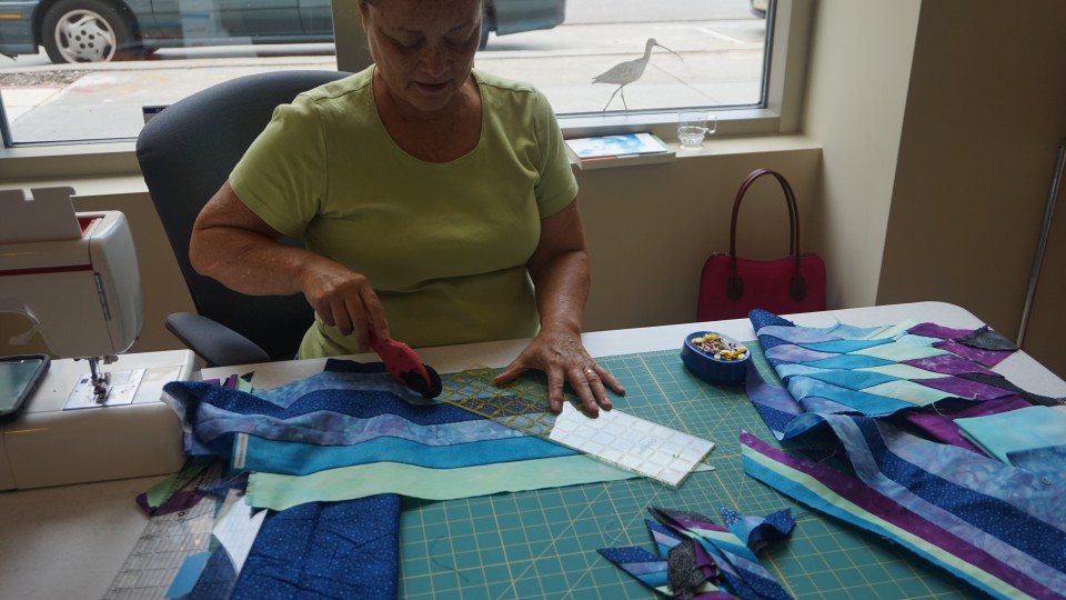Artist Gwen Westerman cuts fabric during her first visit to the Great Plains Art Museum in early September. Westerman, the 2015 Elizabeth Rubendall Artist in Residence, will complete the artwork she started then during her next visit, Nov. 11-14.