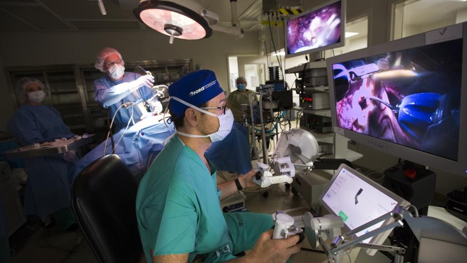 Dmitry Oleynikov, a UNMC professor of surgery, operates a surgical robot as in the background Shane Farritor, a UNL engineering professor, adjusts the camera on the surgical subject in June 2015. The two developed the robot for minimally invasive surgeries. Farritor and Oleynikov's startup company, Virtual Incision, announced March 1 the first use of its miniaturized robot in human surgery.
