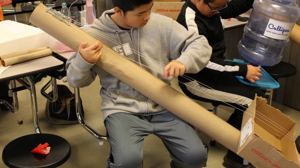 Under the direction of Kennedy Center teaching artist and science educator John Bertles, Science of Sound Spring Break Camp participants experiment with sound on musical instruments created from recycled materials at Dawes Middle School in 2014.