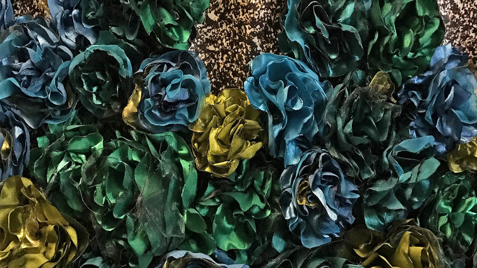Detail showing satin flowers as textile manipulation in the garment "Riqueza," 2017, by Katherine Rodriguez Hernandez.