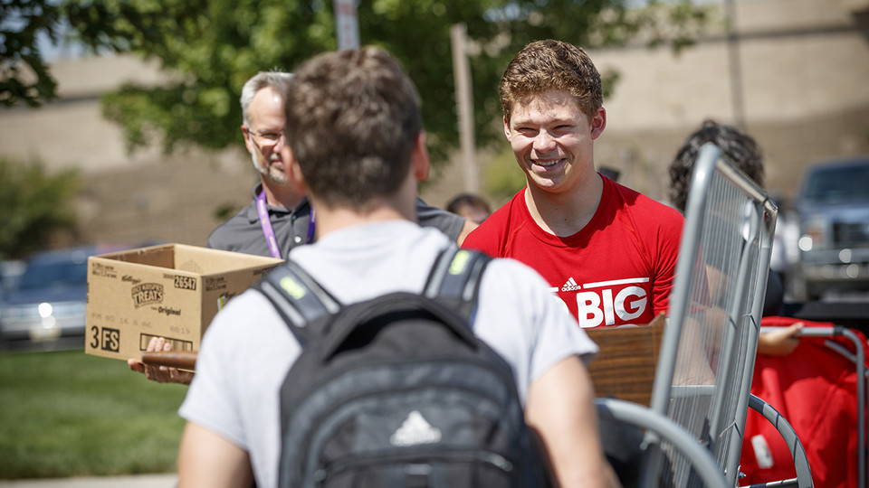 University of Nebraska–Lincoln student Thomas Lilly (right) smiles as he and his roommate, Luke Haberman, carry a futon into Schramm Hall in August 2017. Students at Nebraska will move in from 8 a.m. to 4 p.m. the week of Aug. 13.