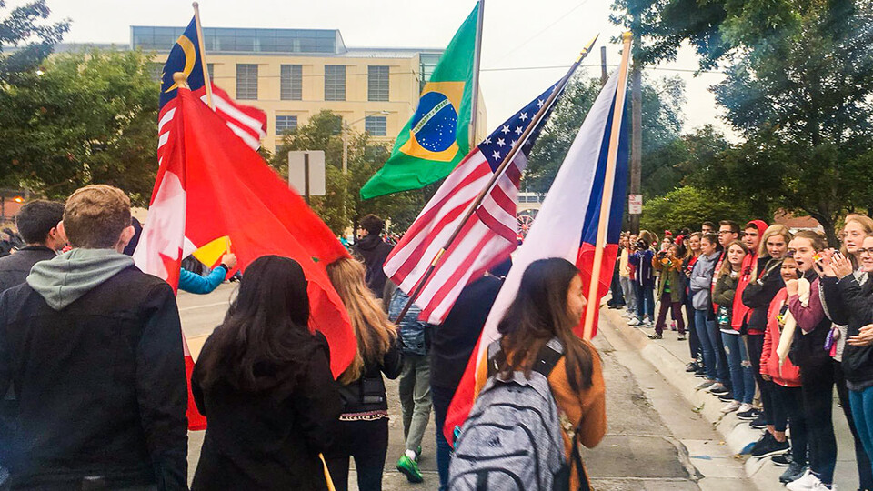 International students hold their country’s flags while marching in the 2019 homecoming parade.