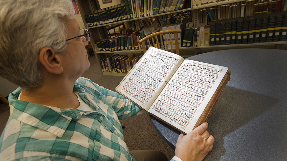Anita Breckbill, professor and music librarian at the University of Nebraska–Lincoln, looks through “Antiphonarium Romanum,” a 405-year-old book of Gregorian chants that was recently donated to Archives and Special Collections by Karen R. Lusk. The only other known copy is located at Yale University.