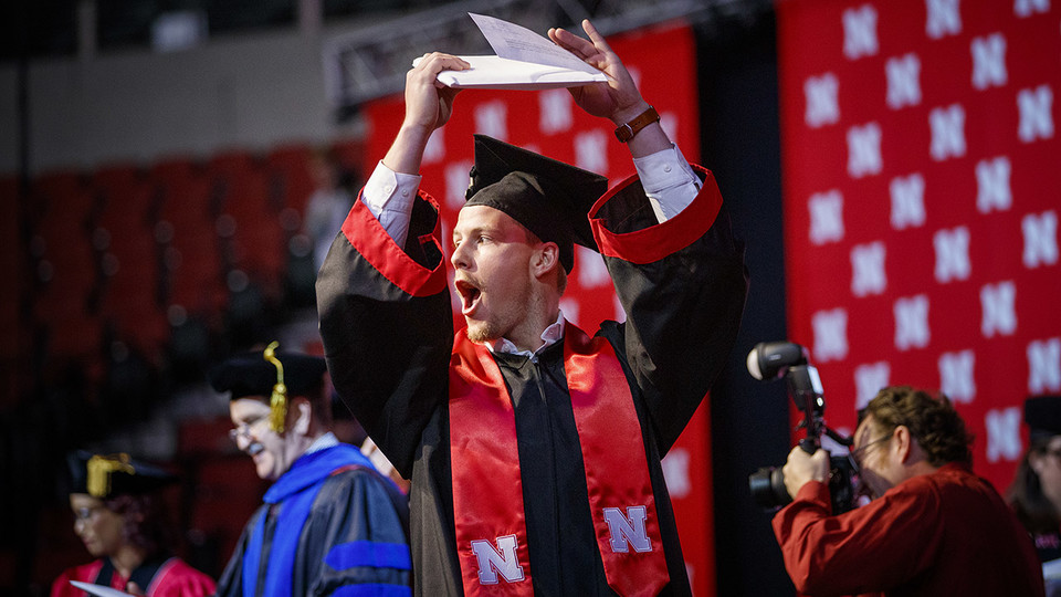Jordan Anderson shows off his new diploma to family and friends during the undergraduate commencement ceremony Dec. 21 at Pinnacle Bank Arena. He earned a Bachelor of Science in Mechanical Engineering.