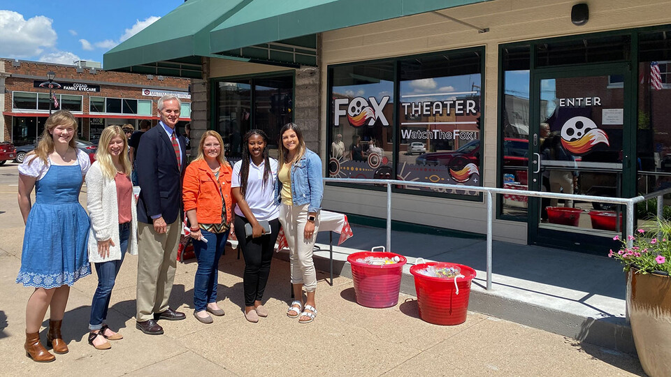 Student fellows Alicia Pannell (left), Tori Pedersen (second from left) and Janet Kabetesi (fifth from left) and community fellows Andrea McClintic (fourth from left) and Stephanie Novoa (sixth from left) are pictured with Lt. Gov. Mike Foley (third from left) at the Fox Theater ribbon cutting in Cozad, Nebraska.