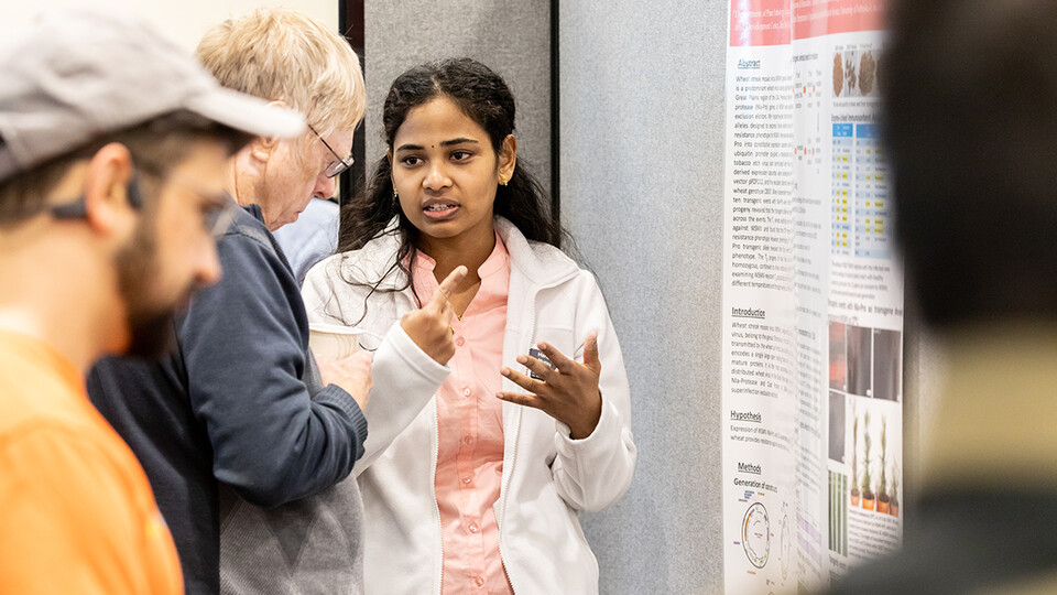 Plant Pathology graduate student Haritha Nunna discusses her presentation, Transgenic wheat harboring viral Nia-Protease gene confers resistance against wheat streak mosaic virus, with poster judge Dr. Kenneth Nickerson, Emeritus Professor, School of Biological Sciences at the 2022 UNL Microbiology Research Symposium.