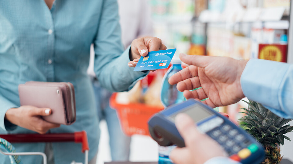 Woman handing cashier a credit card