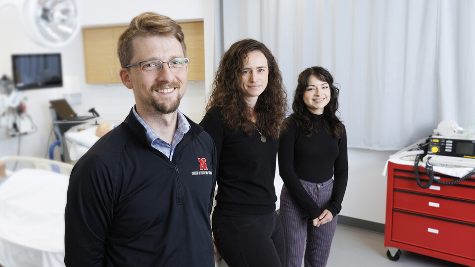 Husker researchers Arthur "Trey" Andrews, Tierney Lorenz and Sara Reyes pose in a patient room.