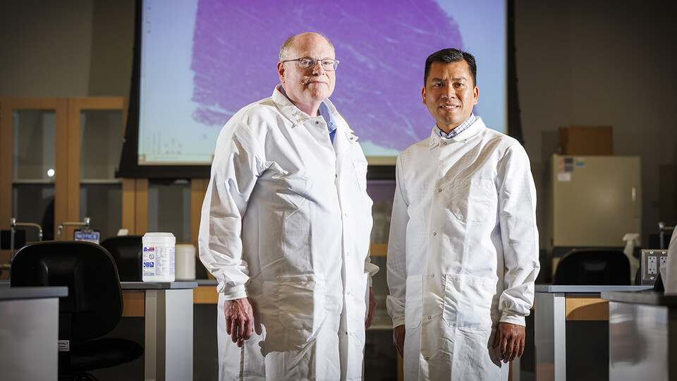 Scott McVey and Hiep Vu stand in a lab