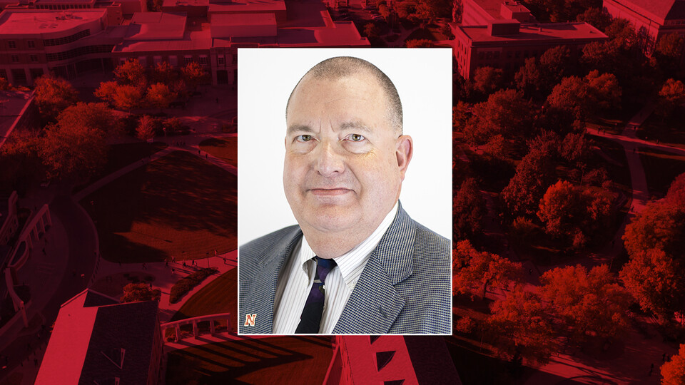 Color portrait of Ronald Faller on red campus background
