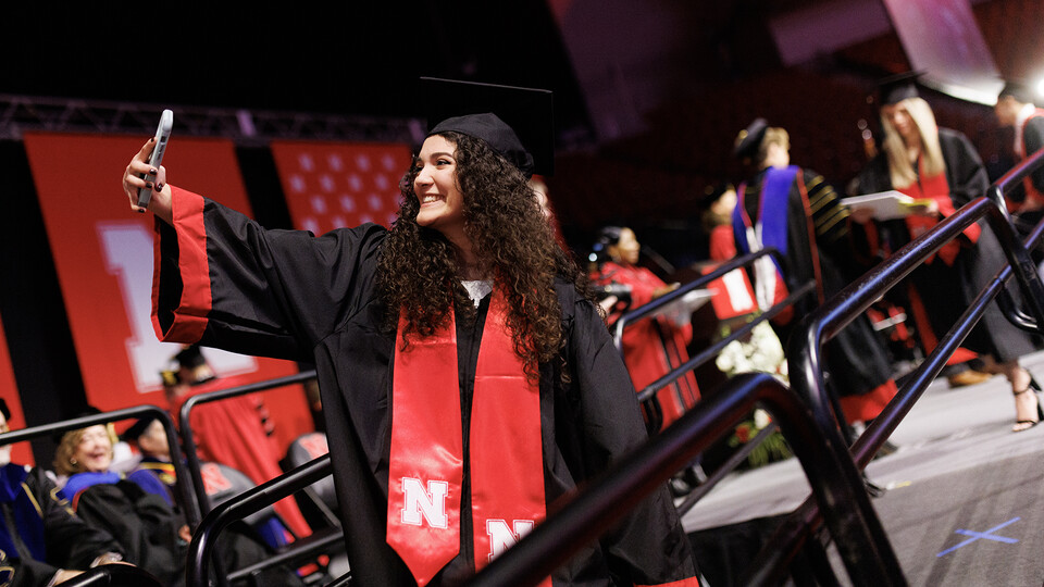 Graduate Ariel Zavala takes a selfie as she walks off stage during the undergraduate commencement ceremony Dec. 17 at Pinnacle Bank Arena. She earned a Bachelor of Science in Animal Science.