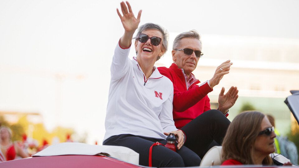 Ronnie and Jane Green ride in a convertible during Nebraska's 2022 Homecoming Parade.
