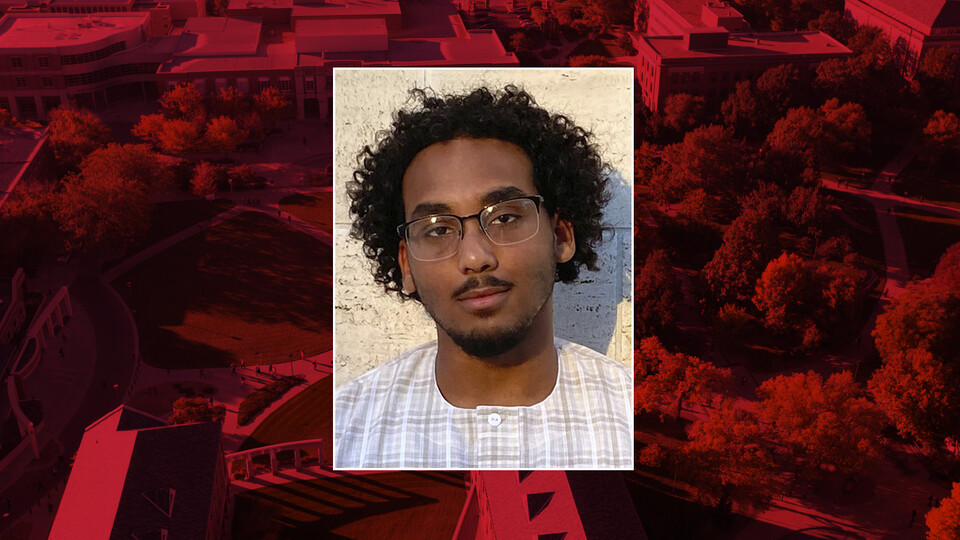 Color photo of Ahmed Alsayid on red campus background
