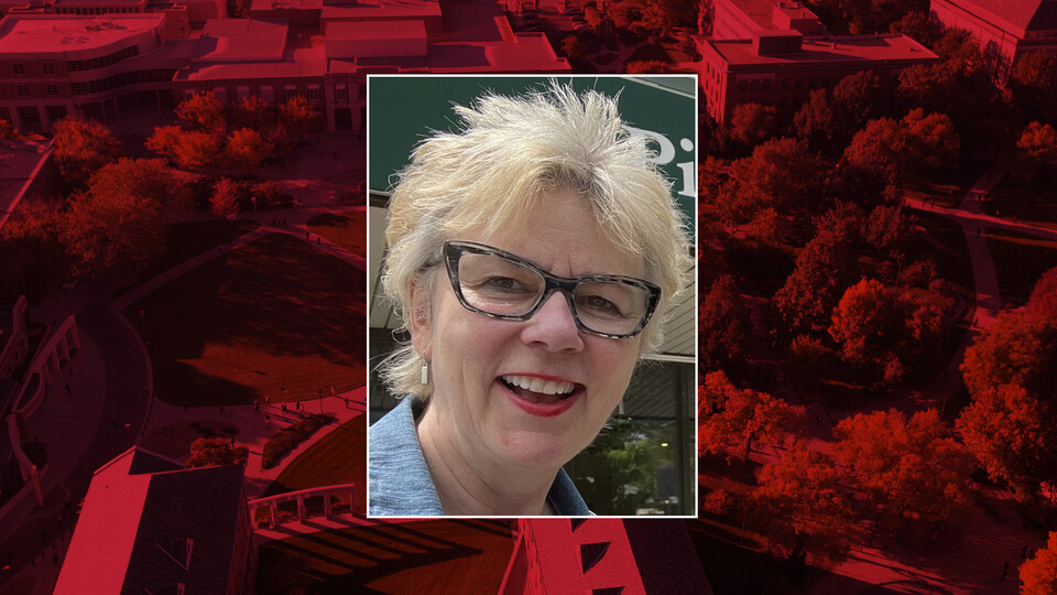 Color photo of Laurie Richards on red campus background