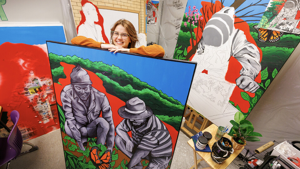 Lincoln Northeast student Peyton Miller stands among colorful murals.