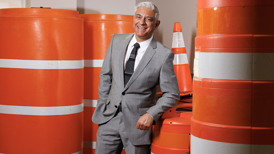 Aemal Khattak, director of the Mid-America Transportation Center, poses amid orange traffic barrels and cones.