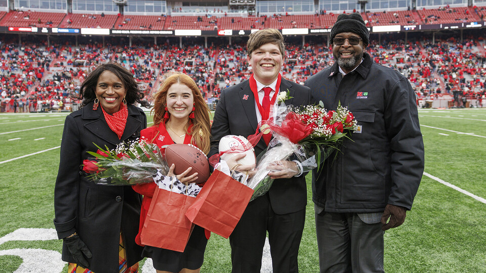 Newly crowned homecoming royalty Hannah-Kate Kinney (second from left) and Preston Kotik (third from left) are joined by Chancellor Rodney Bennett (right) and his wife, Temple (left), on the field at Memorial Stadium.