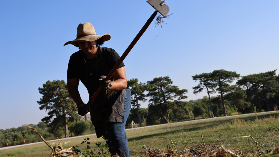 Timothy Thielen breaks up a compost pile with a hoe as part of the Indigenous Youth Food Sovereignty Program.