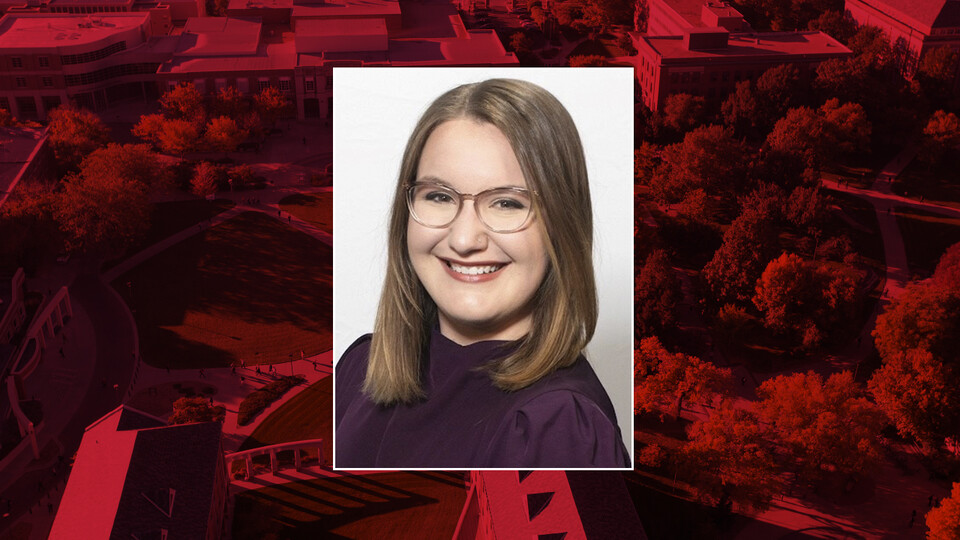 Color portrait of Rebecca (Heckel) McGann on a red campus background