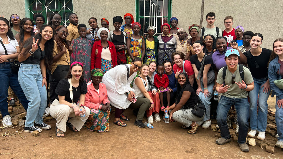 Participants in the Rwanda study abroad trip pose together for a group photo in front of a white building.