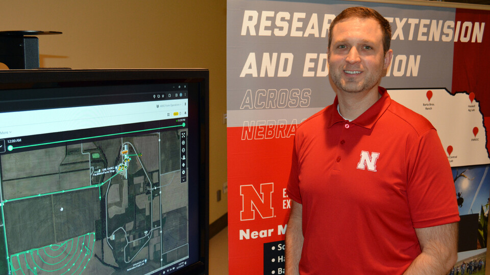 Nate Thorson, research manager for NFarms, stands next to a monitor.